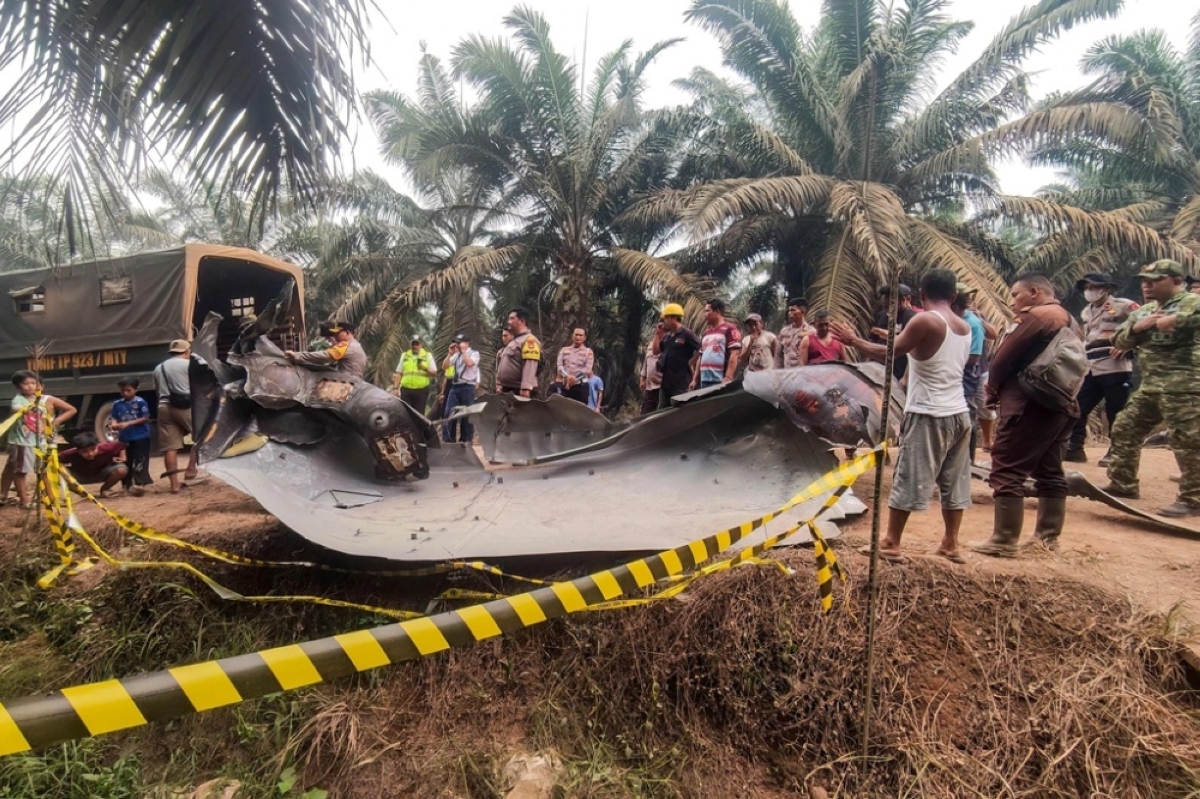 RAISING QUESTIONS Residents, plantation workers and security officials gather around a large charred metallic fragment, suspected to be rocket debris, at an oil palm plantation in East Kotawaringin Regency, Central Kalimantan province, central Indonesia, on Oct. 19, 2026. AFP PHOTO