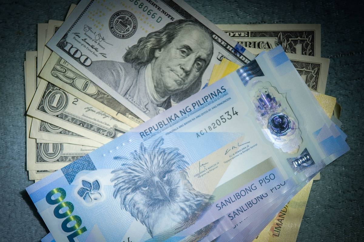 A woman exchanges US dollars for Philippine pesos in Manila, Jan. 10, 2025. PHOTO BY J. GERARD SEGUIA