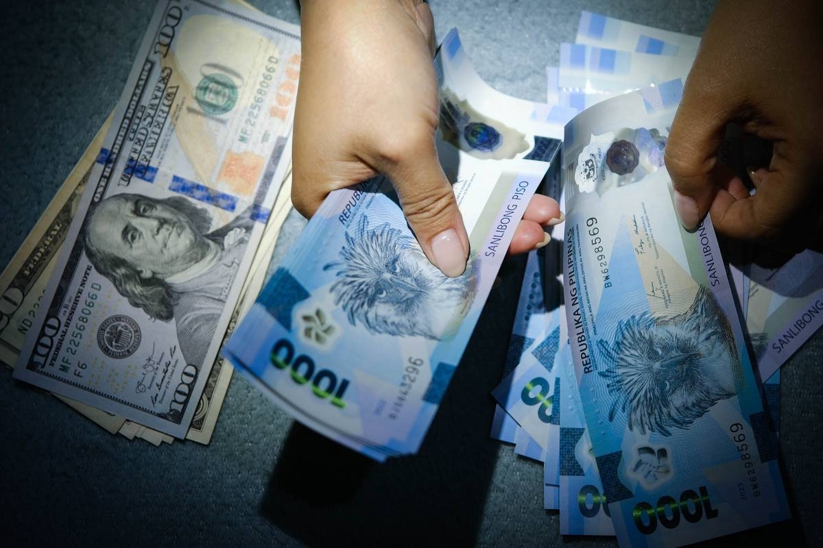A woman exchanges her US dollars for Philippine pesos in Manila. PHOTO BY J. GERARD SEGUIA