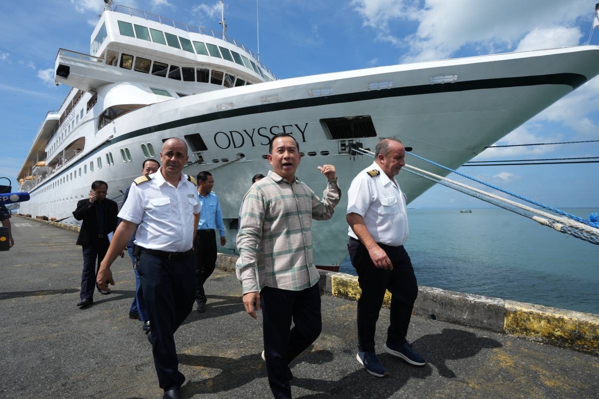 Cambodian Tourism Minister Hout Hak, center, walks with the captains of the U.S. cruise ship, the MV Odyssey Emanuele Giudice, right, and Rodrigo, left, near the cruise ship in Sihanoukville, Cambodia, Thursday, Oct. 29, 2026. (AP Photo/Heng Sinith)