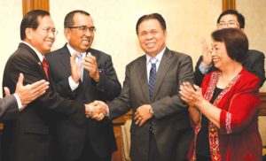 CRUCIAL TALKS Presidential adviser on the peace process, Jesus Dureza (L), shakes hands with Murad Ibrahim (C), chairman of the Moro Islamic Liberation Front (MILF) before sitting down for their first meeting in Kuala Lumpur. AFP PHOTO